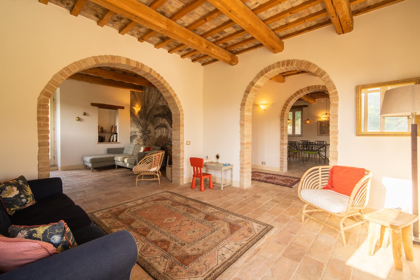 Spacious living room with Marche-style arches and rustic stone floor