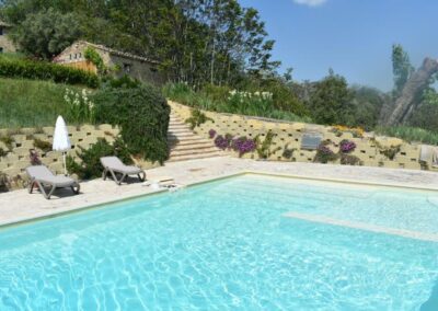 Privézwembad bij Casa Raffaela vakantievilla met ligbedden in de heuvels van de Marche