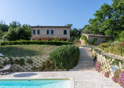 Privézwembad bij Casa Raffaela vakantievilla met ligbedden in de heuvels van de Marche